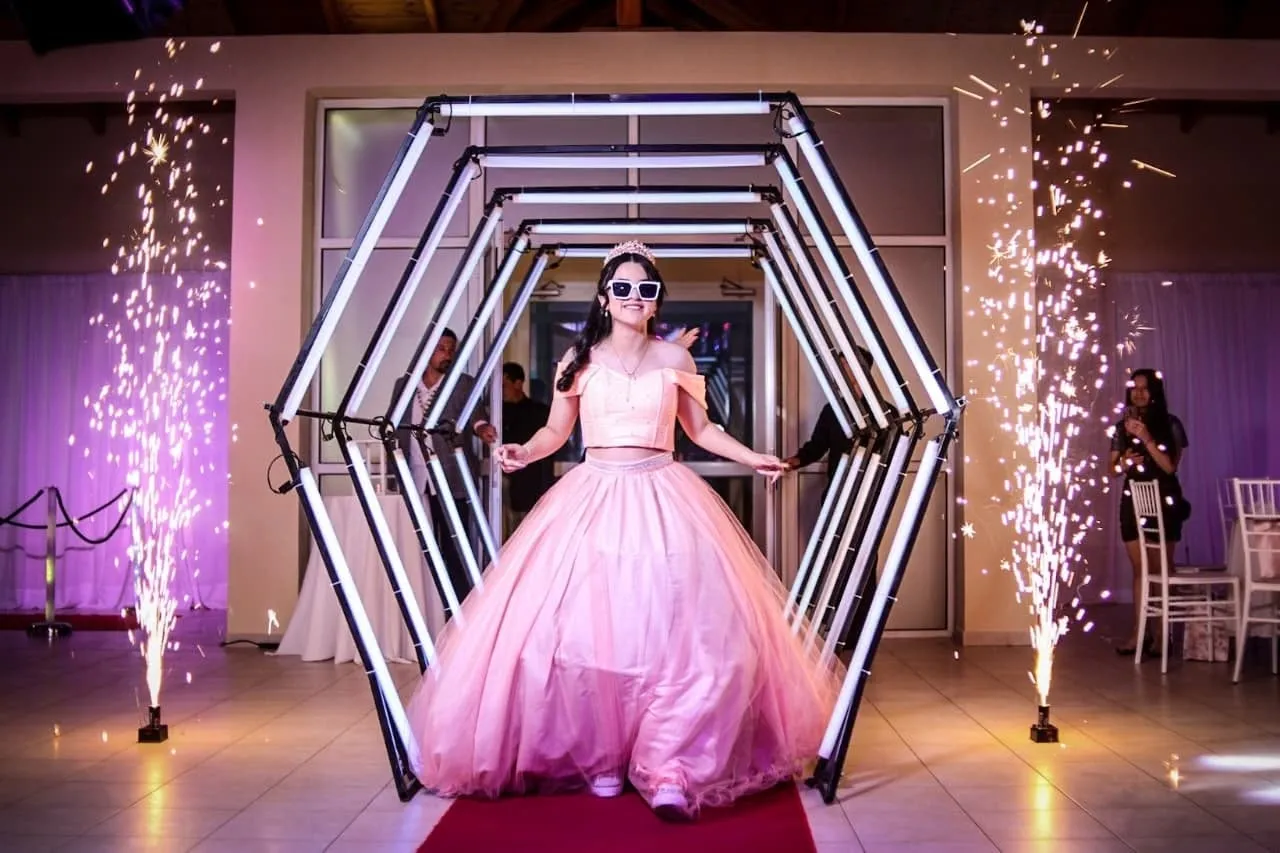 Quinceañera caminando por un túnel iluminado en La Mirada Eventos